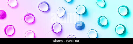 Pattern with ripe coconuts on trendy violet color background. Top View. Copy Space. Pop art design, creative summer concept. Half of coconut in minima Stock Photo