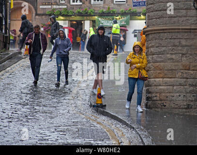 Edinburgh, Scotland, UK. 7th August 2019.Torrential downpours hit the city with thunder and lightning in late afternoon, causing most to run for cover under their umbrellas, slight flooding occurred in the city centre, above Victoria  Street. Stock Photo