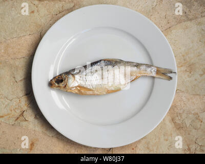 Salted dried fish on a plate top view. Stock Photo