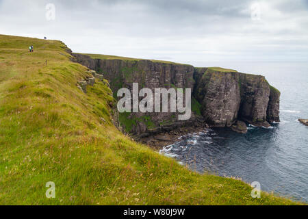 Walkers near the edge of the massive sea cliffs on the isle of Handa Scotland. Stock Photo