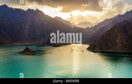 Scenic view of Hatta Lake and Hajar Mountains in the Emirate of Dubai, UAE at sunset Stock Photo