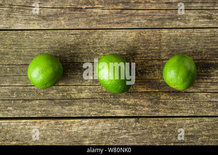 The green limes on old wooden table. Stock Photo