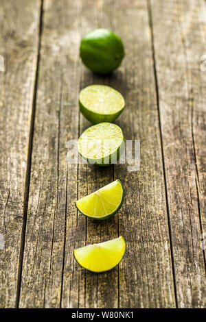 The green sliced lime on old wooden table. Stock Photo