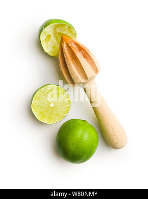 Wooden citrus squeezer and green lime isolated on white table. Stock Photo