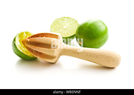 Wooden citrus squeezer and green lime isolated on white table. Stock Photo