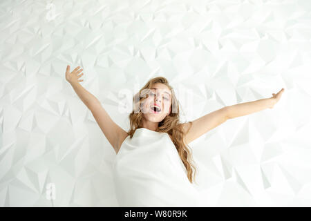 Joyful cute young woman throwing her hands up in the air and smiling Stock Photo