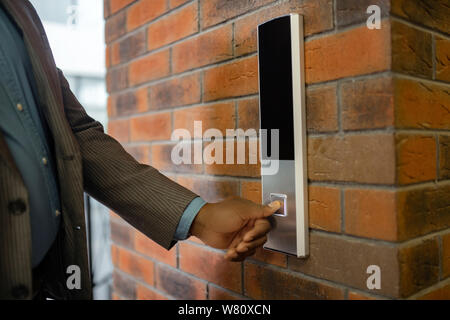 Young businessman wearing striped jacket pressing button Stock Photo