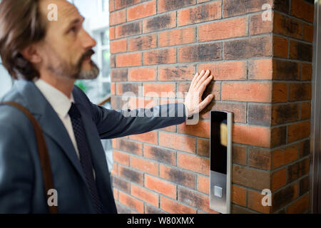 Close up of bearded businessman waiting for lift in the office Stock Photo