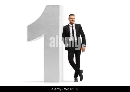 Full length portrait of a businessman in a black suit and tie leaning on number one isolated on white background Stock Photo
