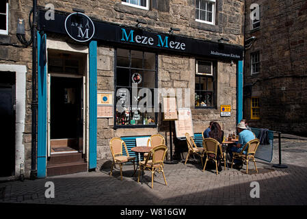 Diners sitting in the moring sunshine outside Meze Meze on Rose Street, Edinburgh, Scotland, UK.