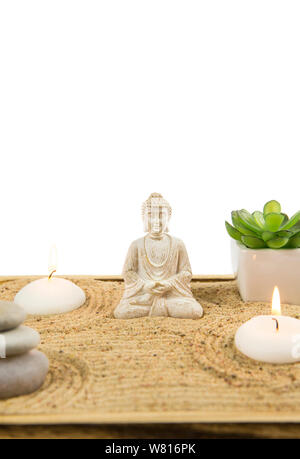 Miniature desk zen sandbox with Buddha sit in Lotus position Room for text. Sand is to recreate the essence of nature. Swirling patterns in the sand r Stock Photo