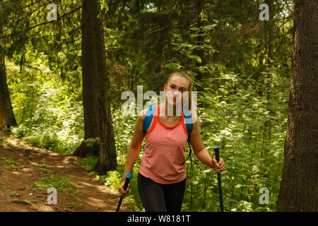 young woman trekking on a trail in a mountain forest Stock Photo