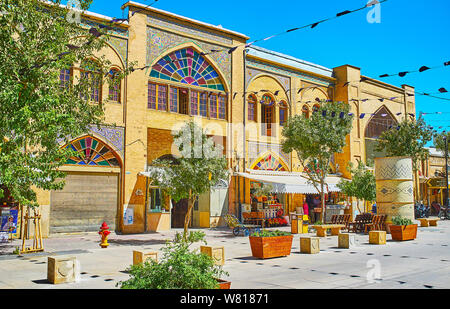 SHIRAZ, IRAN - OCTOBER 14, 2017: Walk the medieval Zand street with its small shops, teahouses, fresh juice bars, souvenir stores, green trees and pla Stock Photo
