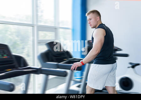 man trains on a treadmill in the gym Stock Photo