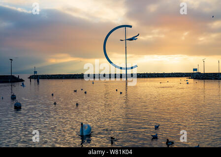Dramatic tranquil silhouette  beautiful sunset at Geneva lake with atmosphere of swans on lake, embankment and Eole sculptural landmark. Stock Photo