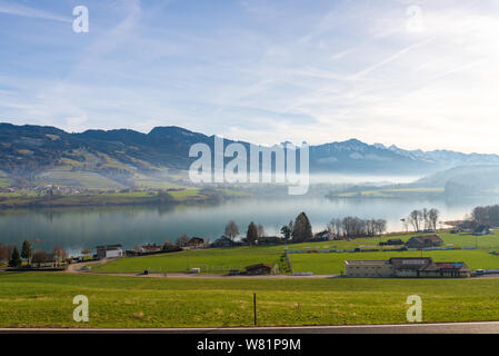 Outdoor beautiful tranquil scenery around lake of Gruyère with background of Alp mountain range in Avry-devant-Pont, Fribourg region, Switzerland. Stock Photo