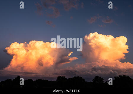 Two storm clouds are building up in anvil producing lightning and thunder and hail Stock Photo