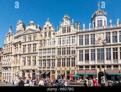Brussels, Belgium - June 22, 2019: Beige stone facades and gables with statues on top and bar-restaurants on ground at northwest side of grand Place. Stock Photo