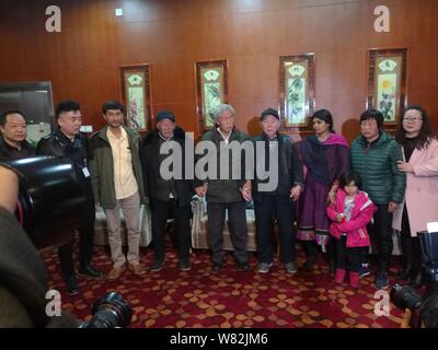 Chinese veteran soldier Wang Qi, center, who was unable to leave India for 54 years, pose for photos with his family after returning to homeland at th Stock Photo