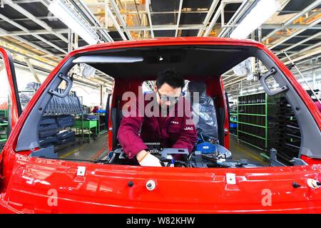 --FILE--A Chinese worker assembles a truck on the assembly line at an ...