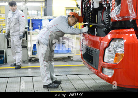 --FILE--A Chinese worker assembles a truck on the assembly line at an ...