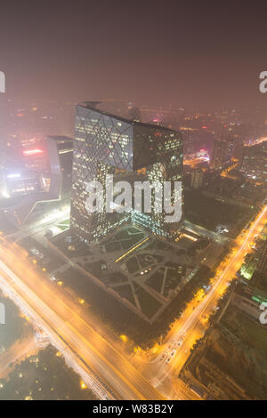 The CCTV Tower, center, the headquarters of China Central Television, and other skyscrapers and high-rise office buildings are seen vaguely in heavy s Stock Photo