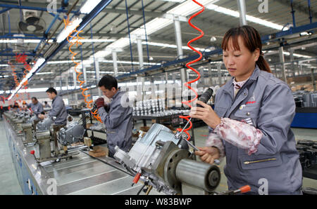 --FILE--Chinese workers assemble a motorbike on the assembly line at a ...
