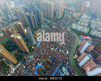 --FILE--An aerial view of a shantytown with old houses next to clusters of modern high-rise residential apartment buildings in Shanghai, China, 7 Dece Stock Photo