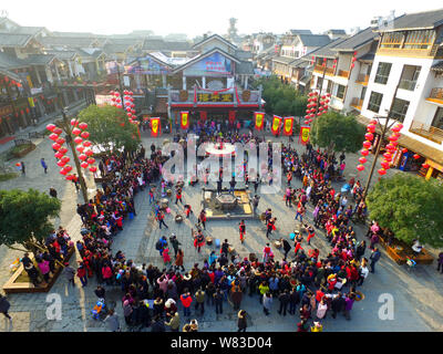 Chinese people of Tujia ethnic minority pound doughs divided from the world's largest glutinous rice cake on an ancient street at Wulingyuan Scenic an Stock Photo