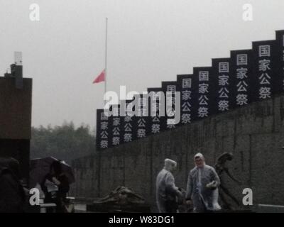 Chinese national flag flies at half-mast to mourn for victims at the Memorial Hall of the Victims in Nanjing Massacre by Japanese Invaders on China's Stock Photo