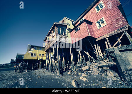 CASTRO, CHILE - FEBRUARY 6, 2016: Palafitos, traditional wooden stilt houses at low tide along Gamboa River in Castro, Chiloe, Chile Stock Photo