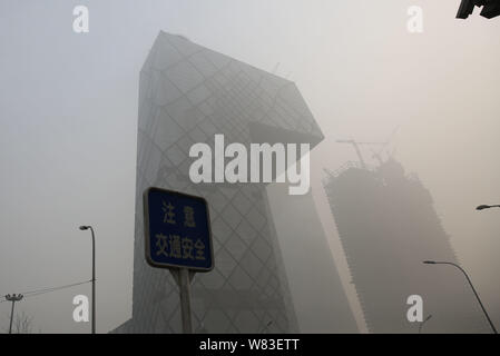 The CCTV Tower, center, the headquarters of China Central Television, and other skyscrapers and high-rise office buildings are seen vaguely in heavy s Stock Photo