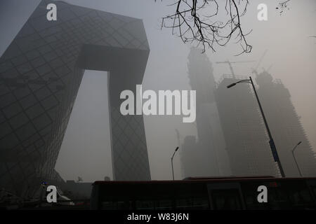 The CCTV Tower, center, the headquarters of China Central Television, and other skyscrapers and high-rise office buildings are seen vaguely in heavy s Stock Photo