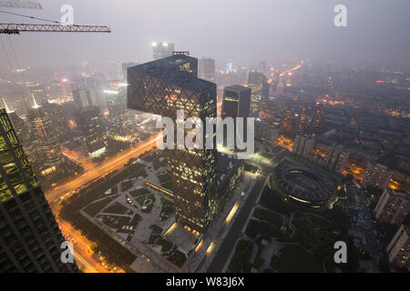 The CCTV Tower, center, the headquarters of China Central Television, and other skyscrapers and high-rise office buildings are seen vaguely in heavy s Stock Photo