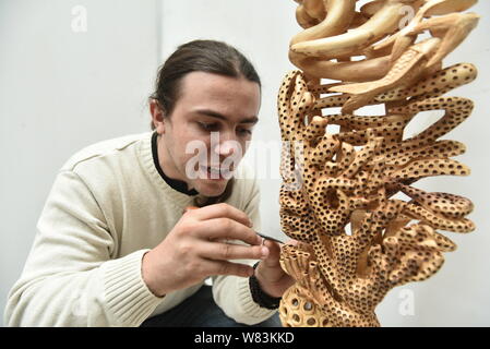 Frenchman Guilhem Bouissou creates an artwork of Dongyang wood carving in Dongyang city, east China's Zhejiang province, 12 November 2016.   Frenchman Stock Photo