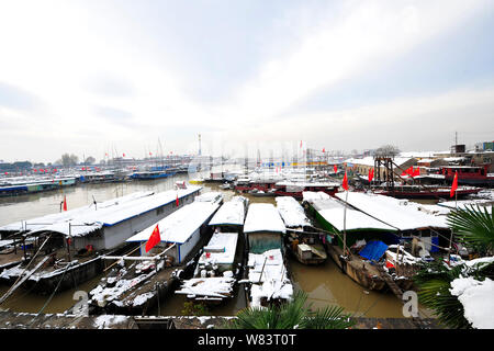 Fishing boats are covered with snow on Hongze Lake in Hongze county, east China's Jiangsu province, 24 November 2016. Stock Photo