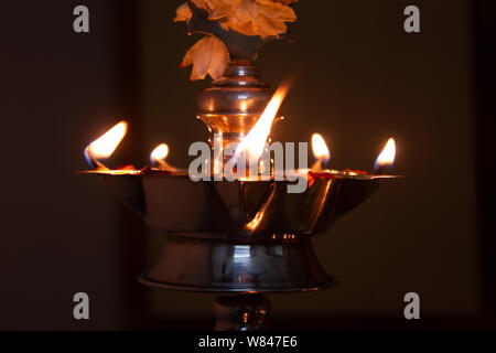 Lamps lit during the prayers to god along with food offering Stock Photo
