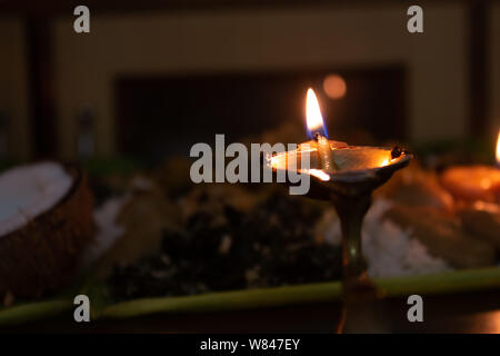 Lamps lit during the prayers to god along with food offering Stock Photo