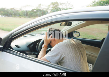 Illness, exhausted, disease, tired for overworked concept. Asian businessman having headache from migraine while he driving car. Stock Photo