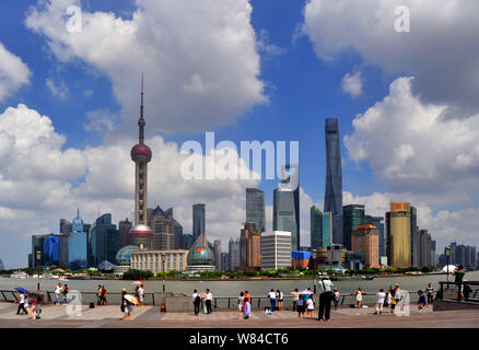 --FILE--Tourists visit the promenade on the Bund along the Huangpu River to view the cityscape of the Lujiazui Financial District with the Oriental Pe Stock Photo