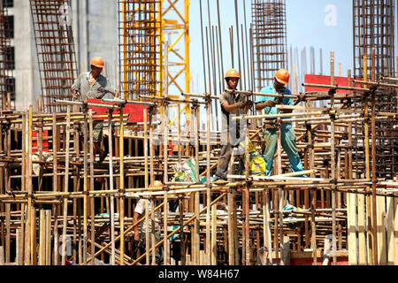 --FILE--Chinese migrant workers labor at the construction site of a real estate project in Nantong city, east China's Jiangsu province, 24 August 2016 Stock Photo