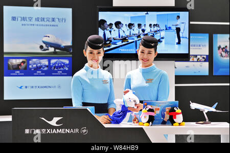 --FILE--Chinese air hostesses pose at the stand of Xiamen Airlines during the Tencent Global Partner Conference 2016 in Fuzhou city, southeast China's Stock Photo