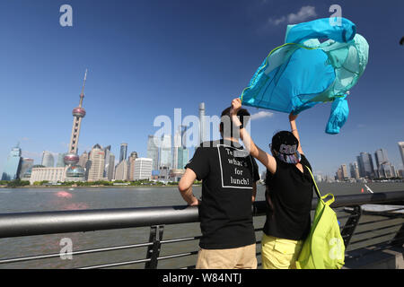 --FILE--Tourists visit the promenade on the Bund along the Huangpu River to view the cityscape of the Lujiazui Financial District with the Oriental Pe Stock Photo