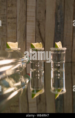 green alcohol drink in glass near fresh and organic limes on pink Stock  Photo by LightFieldStudios