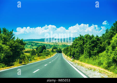 Scenic road in the region of Lika in Croatia, cloudy sky and mountains in background Stock Photo