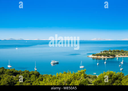 Panoramic view on Kosirina beach lagoon on Murter island in Croatia, anchored sailing boats and yachts on blue sea Stock Photo
