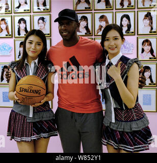 Retired NBA star Chauncey Billups, center, poses with Dai Meng, left, and Wu Zhehan, right, of Chinese girl group SNH48 at their concert in Shanghai, Stock Photo