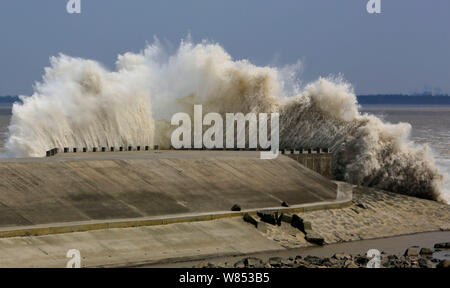 Tidal bore surge past a barrier on the banks of Qiantang River in Hangzhou city, east China's Zhejiang province, 18 September 2016. Stock Photo