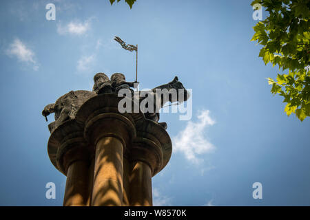 A statue of two men sharing one horse to represent the vow of poverty taken by the Knights Templar is mounted on top of a column just outside Temple Church. Stock Photo