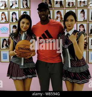 Retired NBA star Chauncey Billups, center, poses with Dai Meng, left, and Wu Zhehan, right, of Chinese girl group SNH48 at their concert in Shanghai, Stock Photo